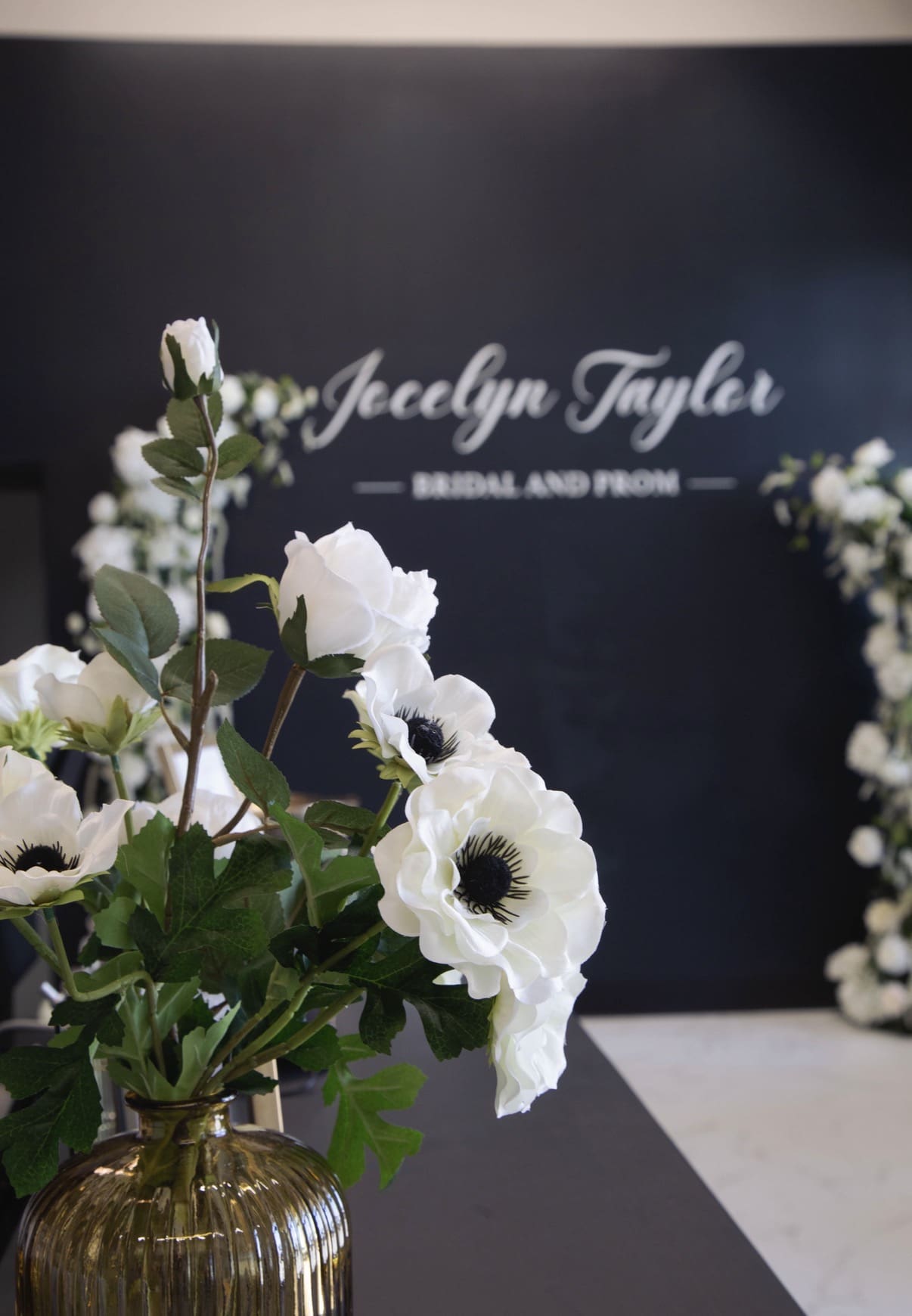Flowers with Jocelyn Taylor logo on wall in background